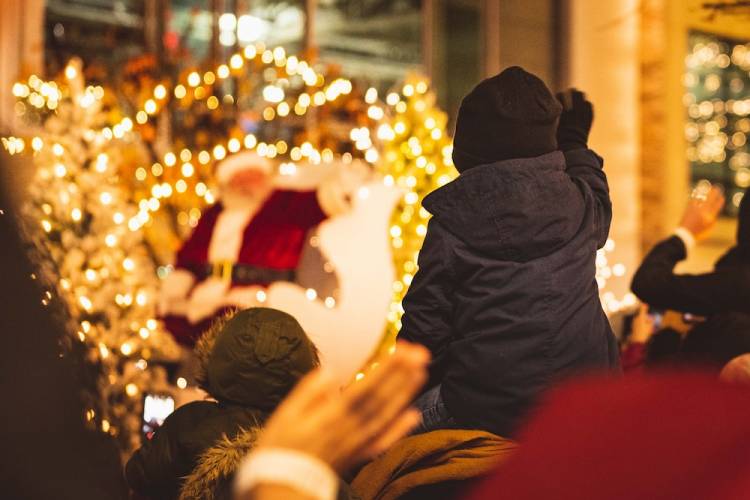 Child waving to Santa during holiday parade. 