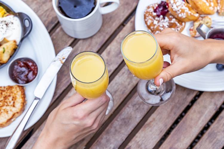 two mimosas clinking at brunch