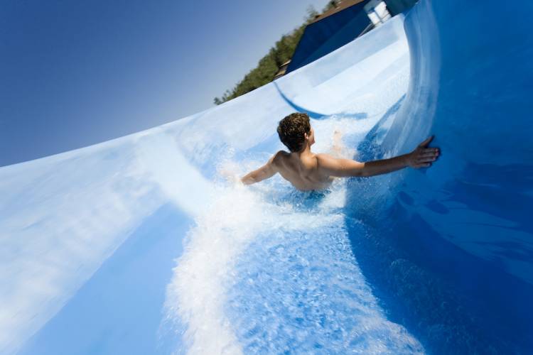 child sliding down water slide at water park