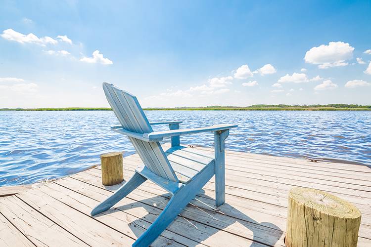 Blue adirondack chair on a dock overlooking Back Bay in Sandbridge Beach Virginia